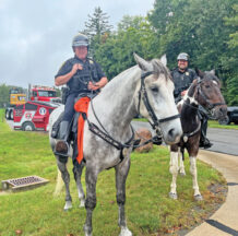 Cleveland MetroParks Police Mounted Unit officers Jim Newman and Trevor Poole smile for the camera alongside their partners, Blue and Tank. Photos by Adriana Gaziewski